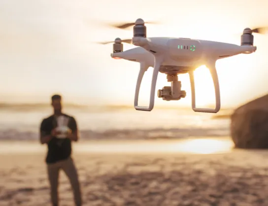 operator drona na tle zachodzącego słońca