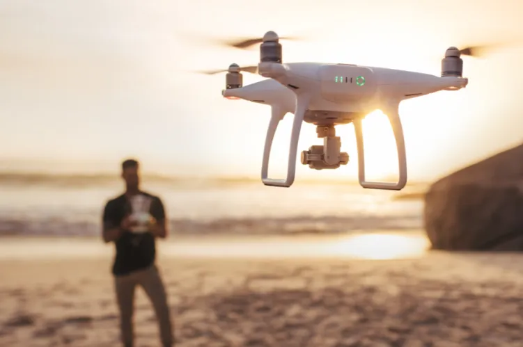 operator drona na tle zachodzącego słońca