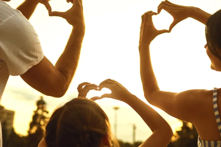 rodzina ze złożonymi w serce rękoma 