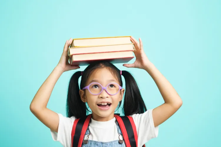 dziewczynka z książkami na głowie 