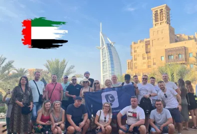 grupa ludzi na tle panoramy Dubaju